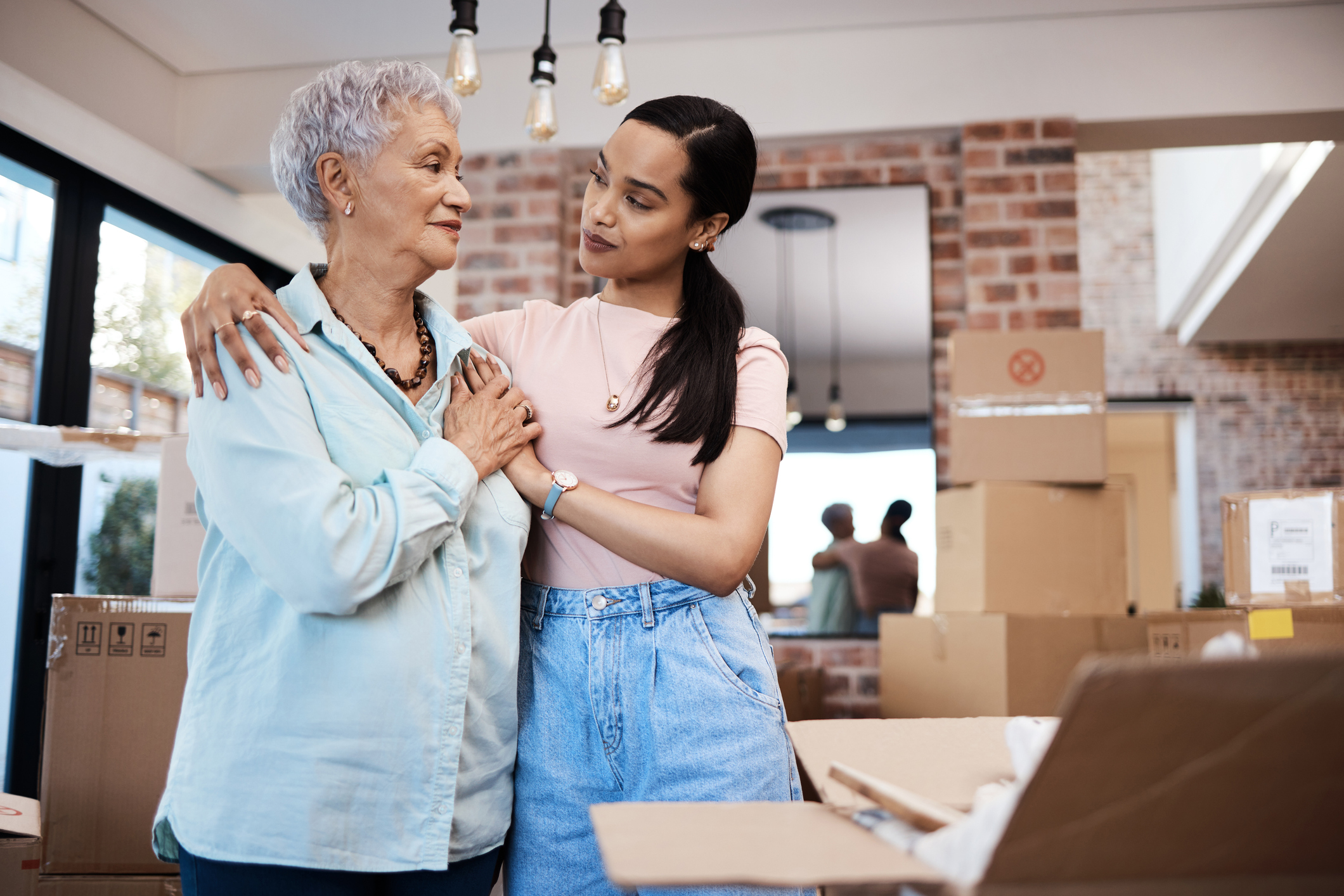 Senior woman packing up her belongings with her adult daughter in preparation for a move to assisted living.